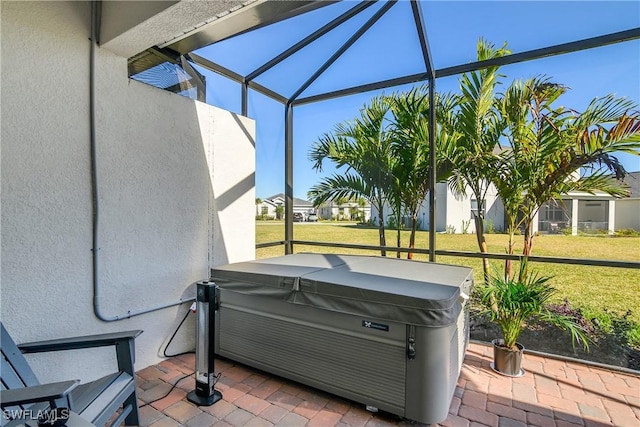 view of patio / terrace with a hot tub and glass enclosure