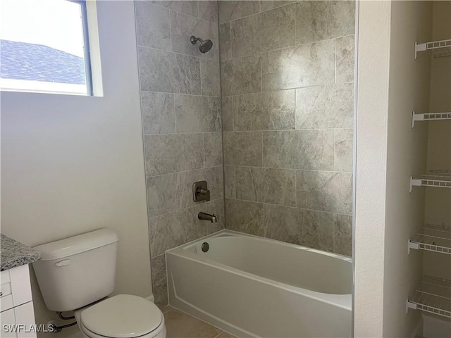 full bathroom featuring vanity, tile patterned floors, toilet, and tiled shower / bath