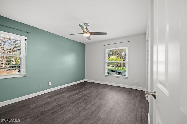 empty room with dark hardwood / wood-style flooring and ceiling fan