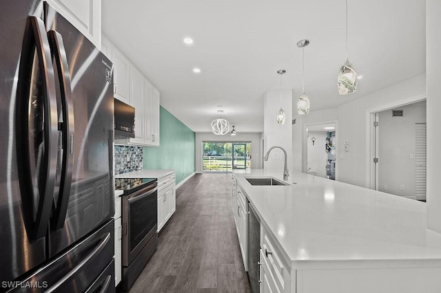 kitchen featuring sink, a large island with sink, stainless steel appliances, white cabinets, and hanging light fixtures