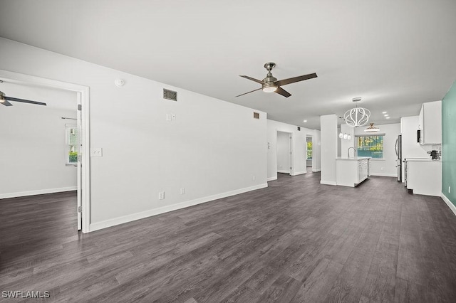 unfurnished living room with sink, dark hardwood / wood-style floors, and ceiling fan