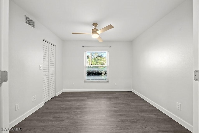 unfurnished bedroom featuring dark wood-type flooring, ceiling fan, and a closet