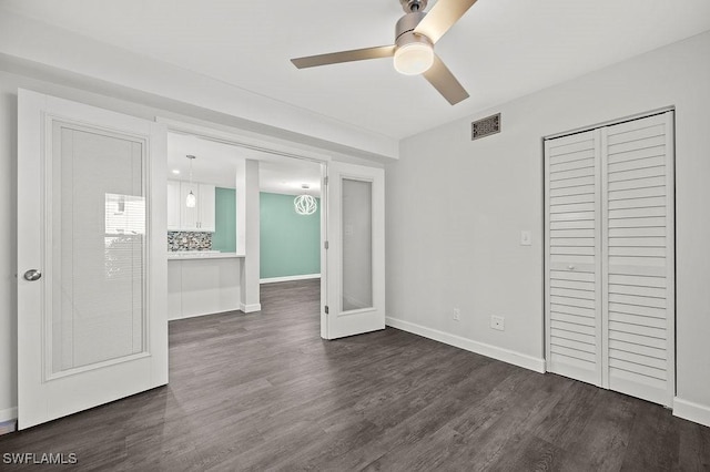 unfurnished bedroom with a closet, dark hardwood / wood-style floors, and ceiling fan