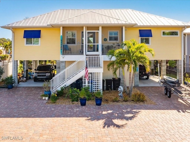 view of front of property with a carport, covered porch, metal roof, and stairs