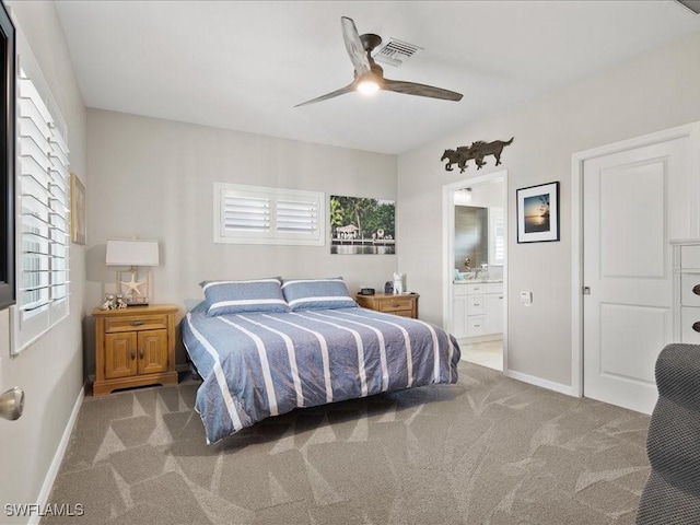 carpeted bedroom with visible vents, connected bathroom, baseboards, and ceiling fan