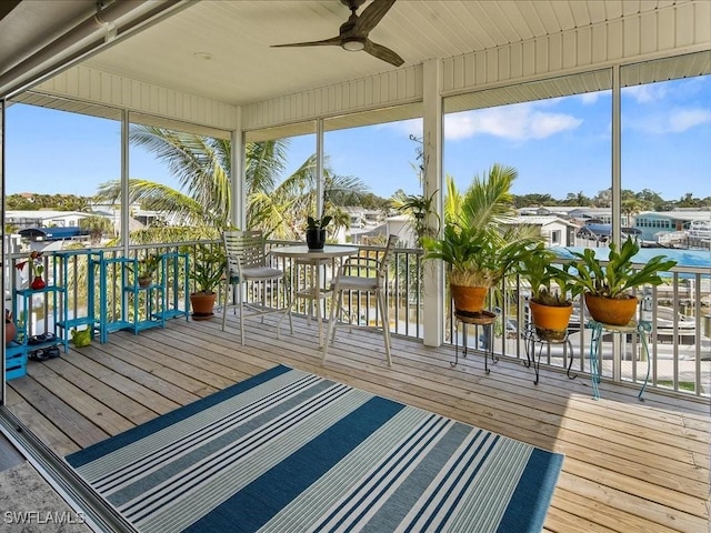 unfurnished sunroom with ceiling fan