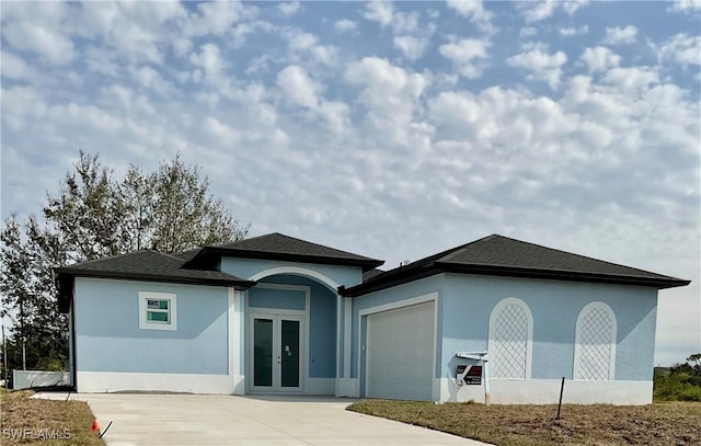 view of front of property with a garage and french doors