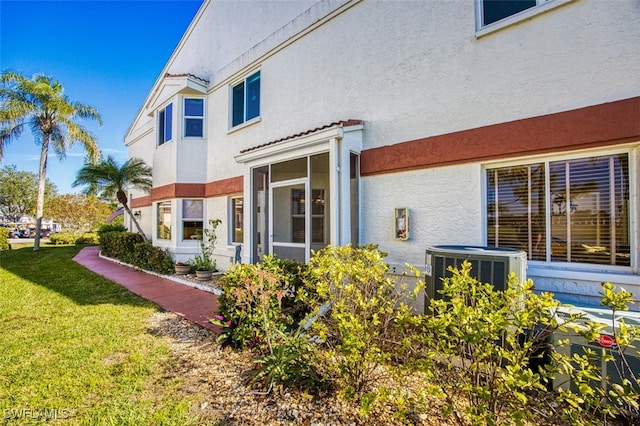 rear view of property featuring cooling unit and a yard