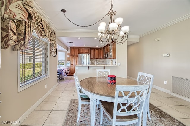 dining room featuring crown molding, sink, light tile patterned floors, and an inviting chandelier