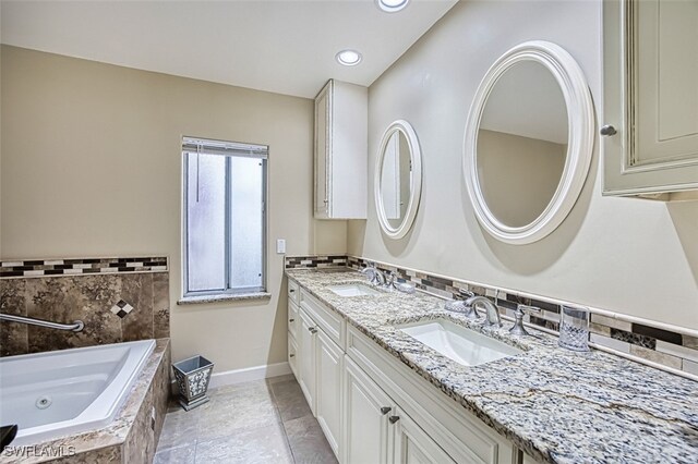 bathroom featuring a relaxing tiled tub and vanity