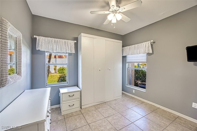 unfurnished bedroom with light tile patterned floors, ceiling fan, and a closet