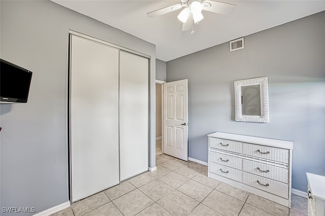 unfurnished bedroom featuring light tile patterned flooring, ceiling fan, and a closet