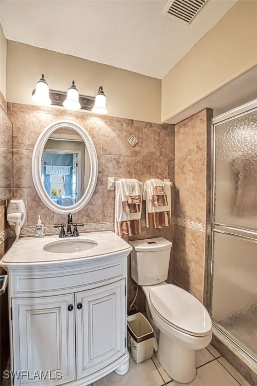 bathroom featuring tile patterned flooring, tile walls, and an enclosed shower