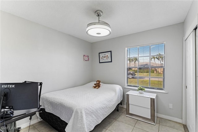 tiled bedroom with a closet and a textured ceiling