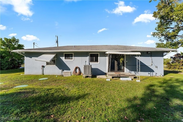 back of house featuring central AC and a lawn