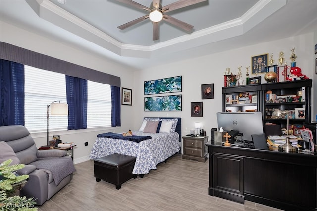 bedroom with crown molding, ceiling fan, a raised ceiling, and light hardwood / wood-style floors