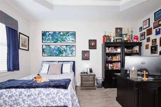 bedroom with a raised ceiling and ornamental molding