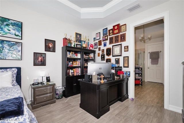 office area with an inviting chandelier, a tray ceiling, crown molding, and light hardwood / wood-style flooring