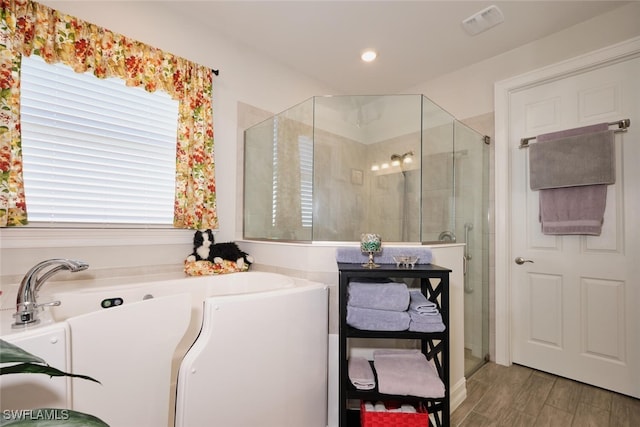 bathroom with hardwood / wood-style flooring and a shower with door