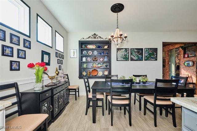 dining space featuring an inviting chandelier and light hardwood / wood-style flooring