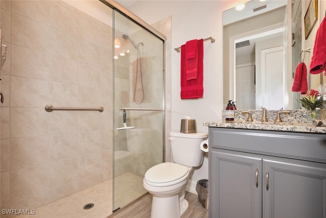 bathroom featuring vanity, an enclosed shower, and toilet