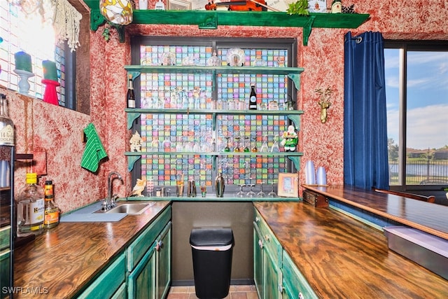 bar featuring wood counters, sink, and green cabinets