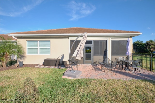 rear view of house featuring a lawn and a patio area