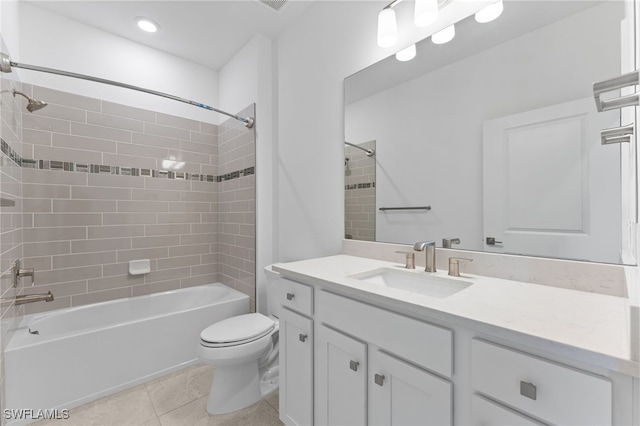 full bathroom with tiled shower / bath, toilet, tile patterned floors, and vanity