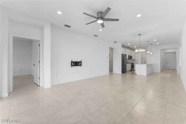 unfurnished living room featuring sink and ceiling fan with notable chandelier