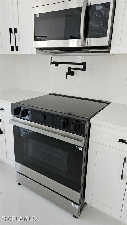 kitchen with white cabinetry and electric range oven