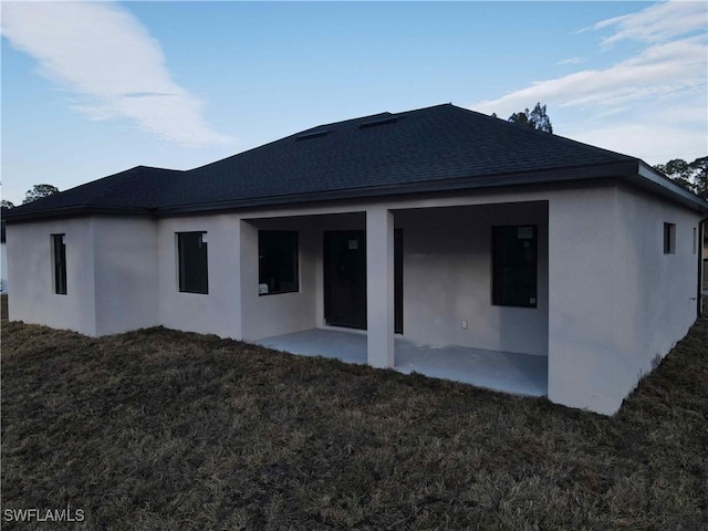 rear view of property featuring a patio and a lawn