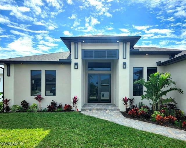 property entrance featuring a yard and french doors