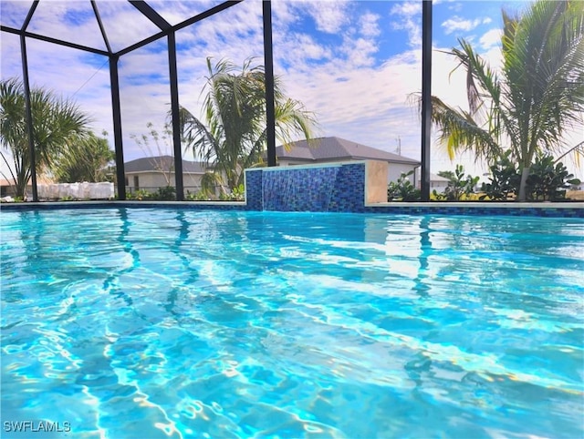 view of pool with a lanai and pool water feature