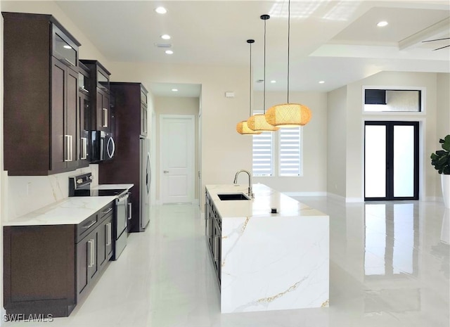 kitchen with sink, hanging light fixtures, a large island, light stone counters, and stainless steel appliances