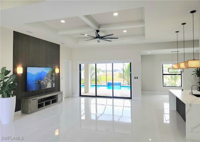 living room with coffered ceiling, sink, beam ceiling, and a healthy amount of sunlight