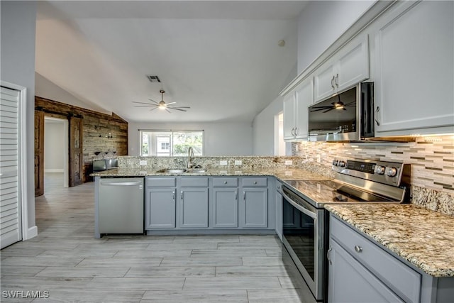 kitchen with sink, ceiling fan, backsplash, stainless steel appliances, and kitchen peninsula