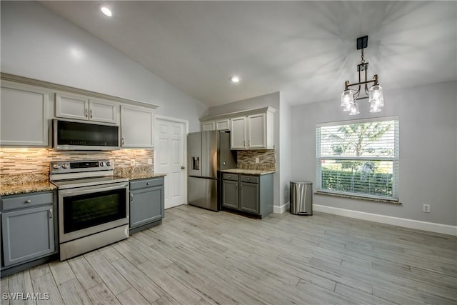 kitchen featuring vaulted ceiling, gray cabinetry, hanging light fixtures, light hardwood / wood-style floors, and stainless steel appliances