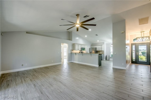 unfurnished living room with ceiling fan, high vaulted ceiling, and light hardwood / wood-style flooring