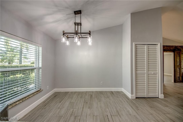 unfurnished dining area with a notable chandelier and light wood-type flooring