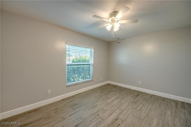 spare room with ceiling fan and light wood-type flooring