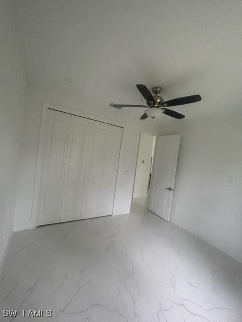 unfurnished bedroom with ceiling fan and a closet