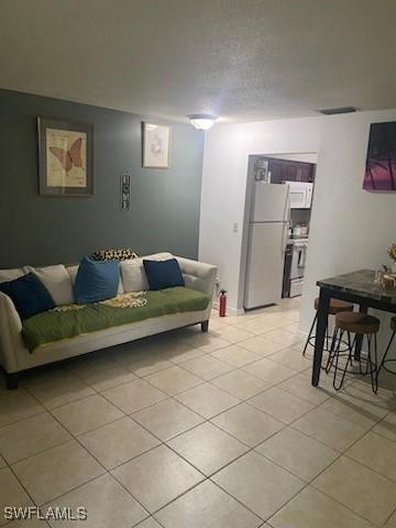 tiled living room featuring a textured ceiling