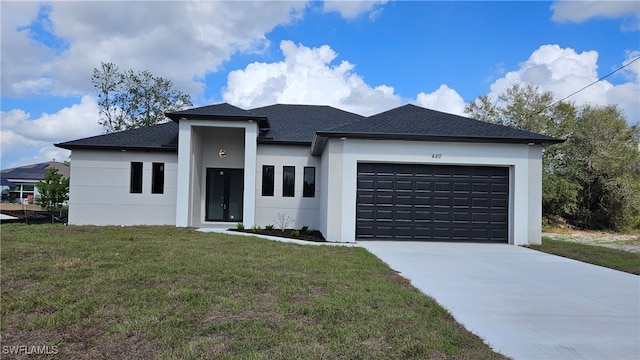 view of front facade featuring a shingled roof, concrete driveway, an attached garage, a front lawn, and stucco siding