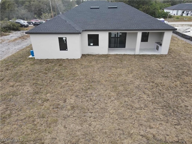 back of house featuring a patio and a lawn