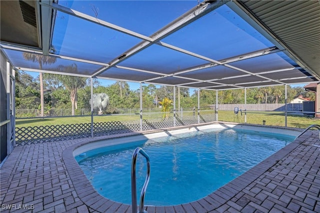 view of pool with a yard, glass enclosure, and a patio area