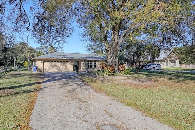 ranch-style home featuring a garage and a front yard