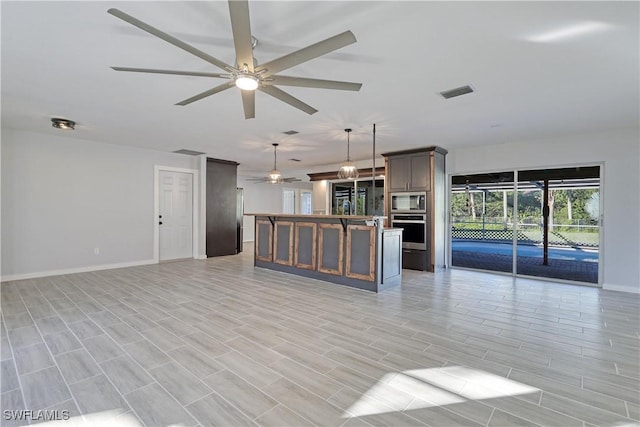 unfurnished living room with ceiling fan