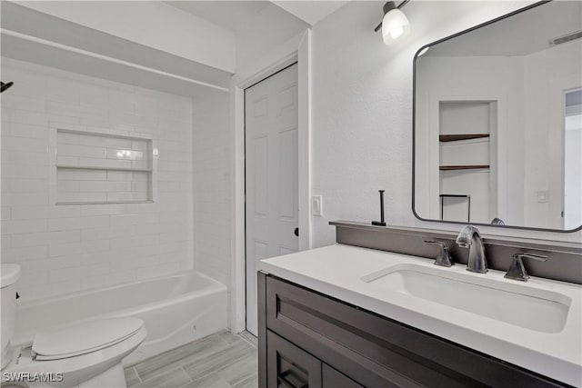 full bathroom featuring vanity, tiled shower / bath combo, and toilet