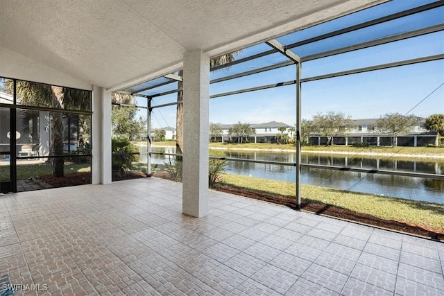 unfurnished sunroom featuring a water view