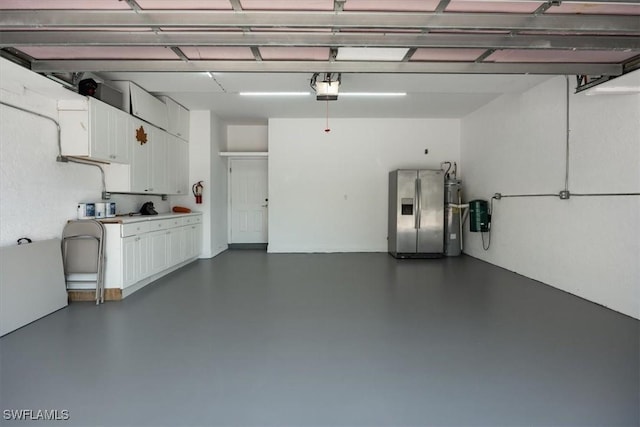 garage featuring stainless steel fridge and a garage door opener